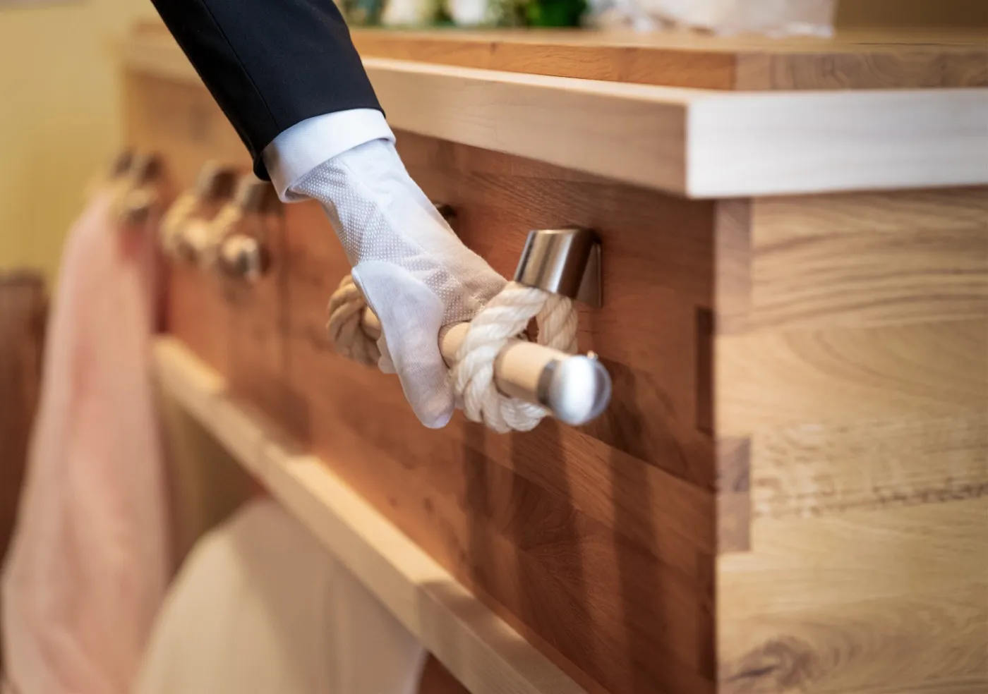 Bestatter mit weißem Handschuh am Sarggriff